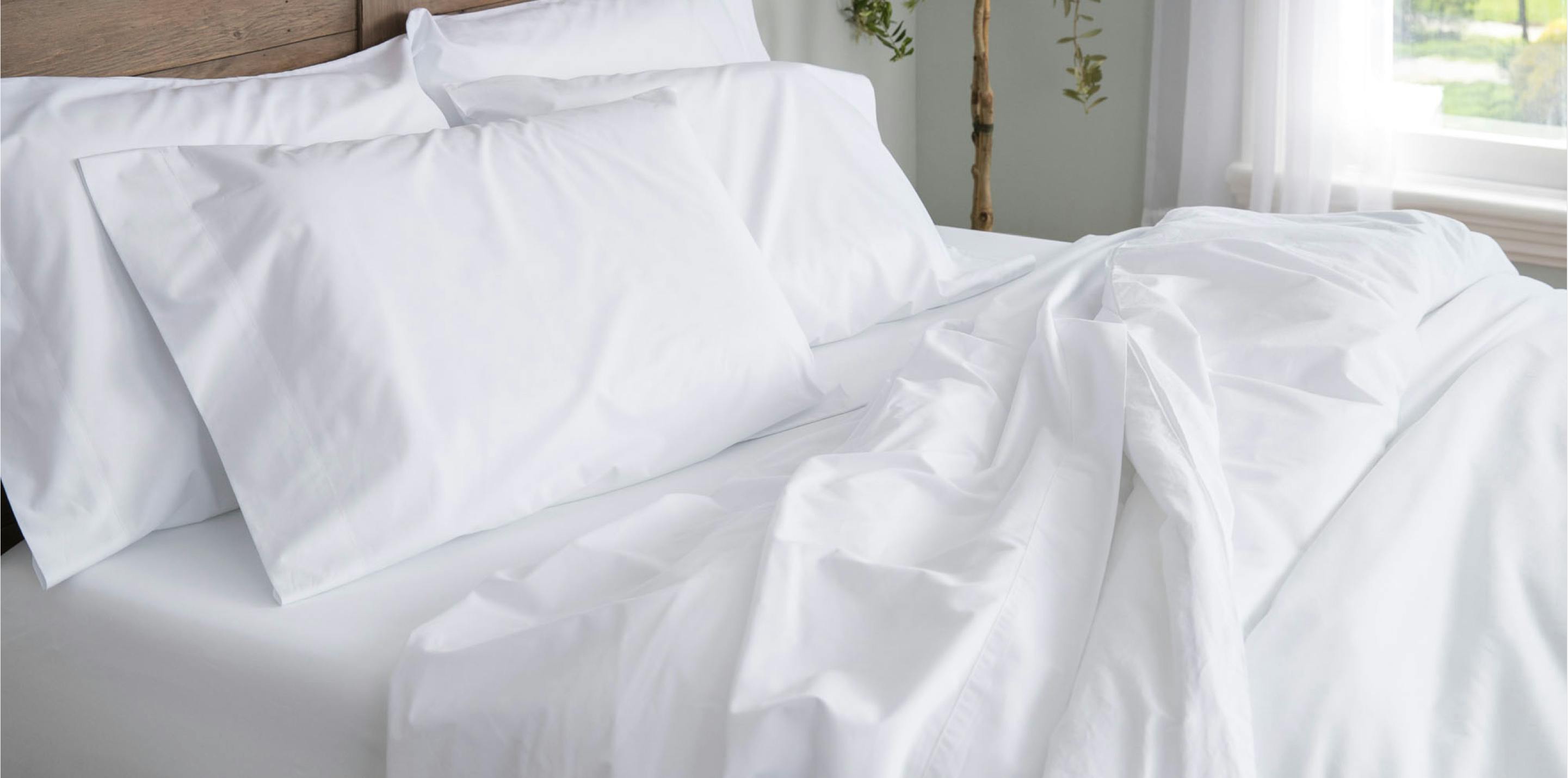 A closeup of a Tuft and Needle bed with cloud bedding