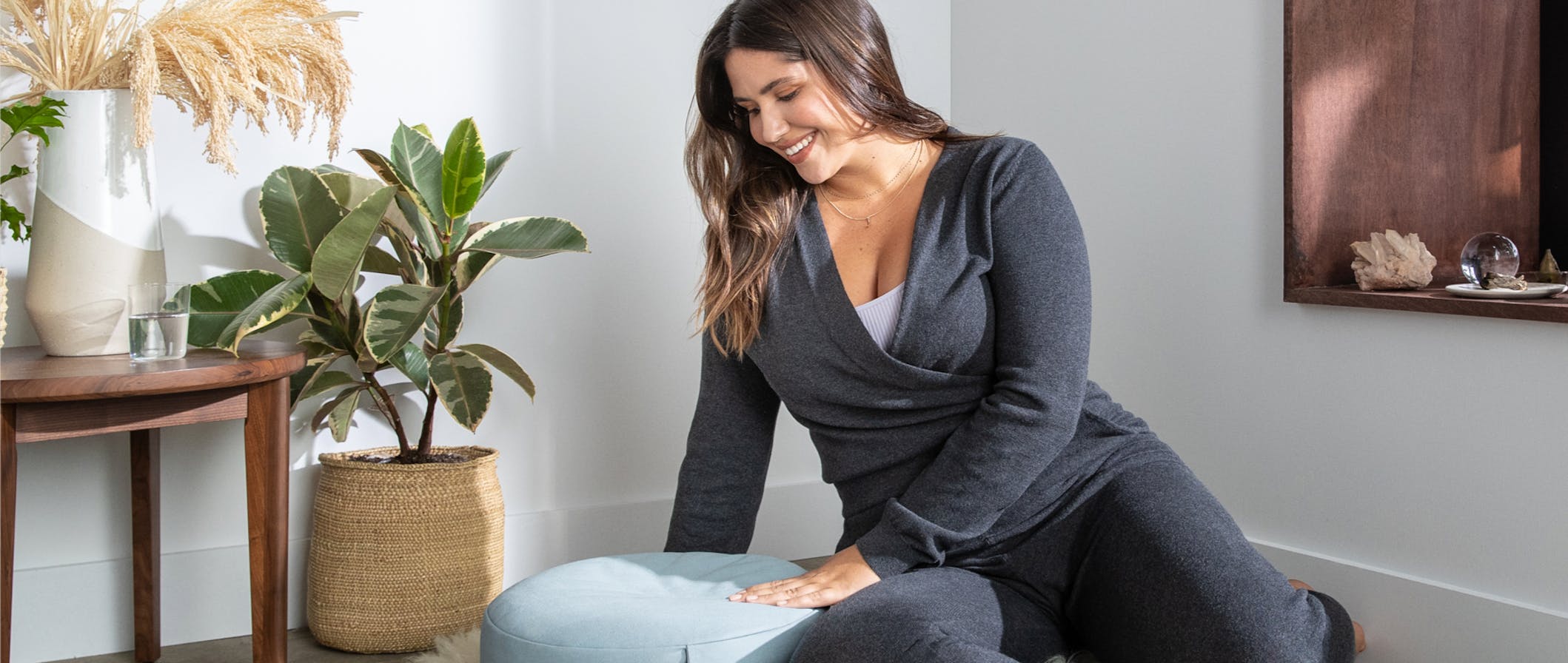 Woman sitting on the ground with the Meditation Cushion.