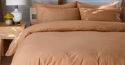 Percale Duvet Cover and Sheets on made bed in Canyon color. 
