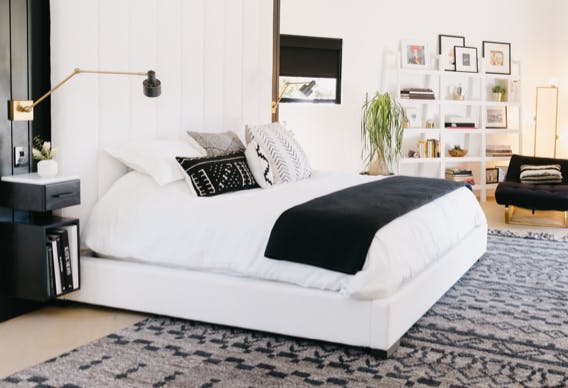 A made bed in a room styled with black and white accents.