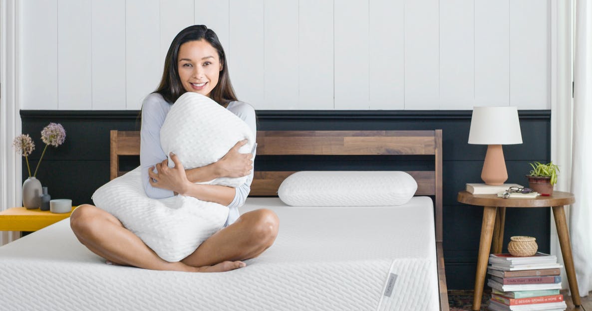 Woman holding a Tuft and Needle original foam pillow