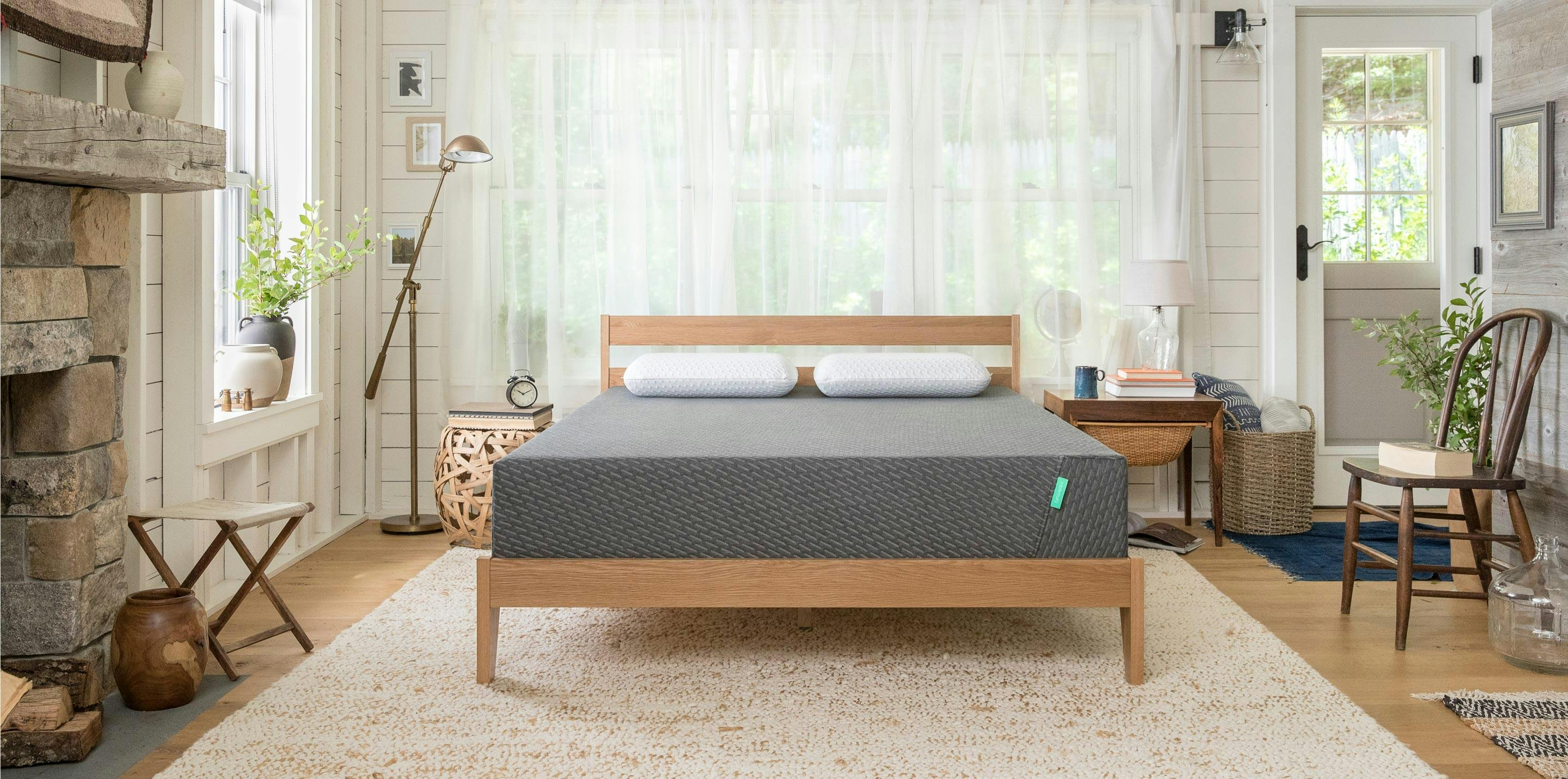 A Tuft & Needle Mint Mattress on a wood frame in a bedroom