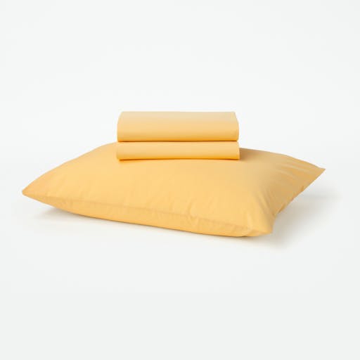 Our Sunshine color toddler sheet set folded sitting on top of a pillow