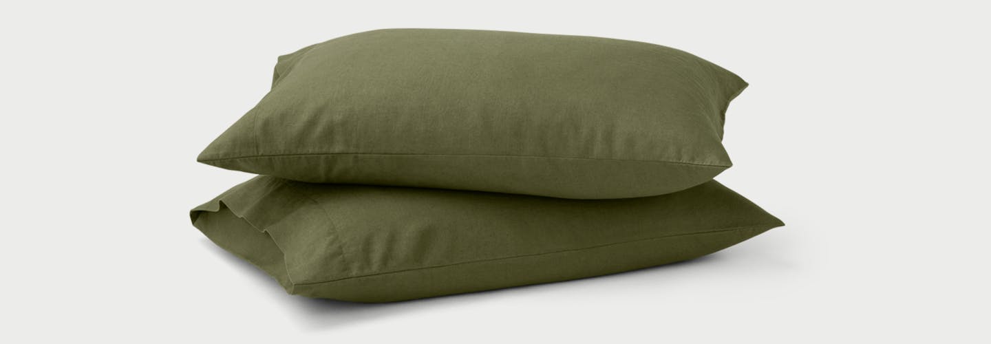 Two Linen Pillowcases on pillows in Moss color.