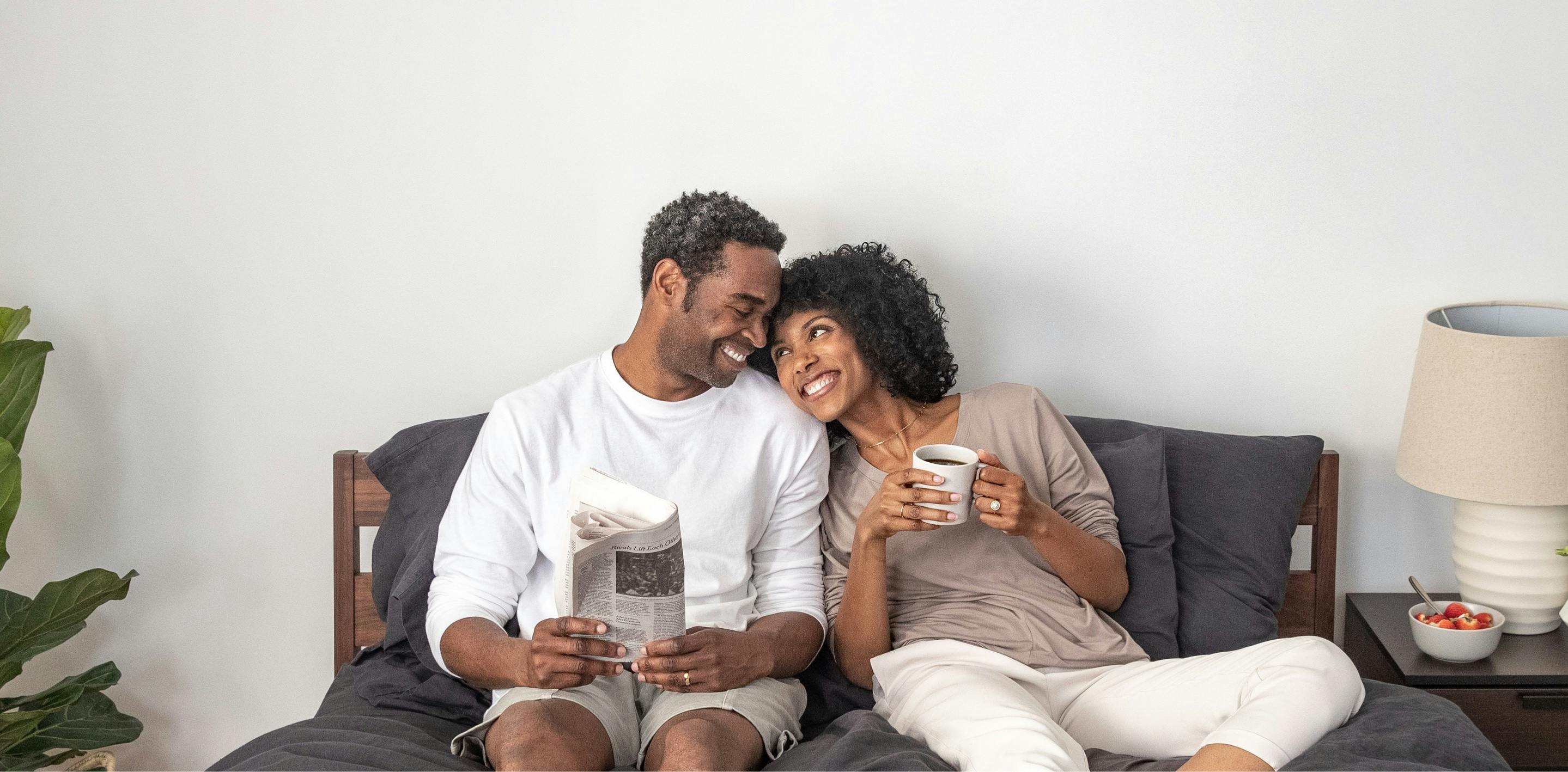 A man and woman sitting on a bed