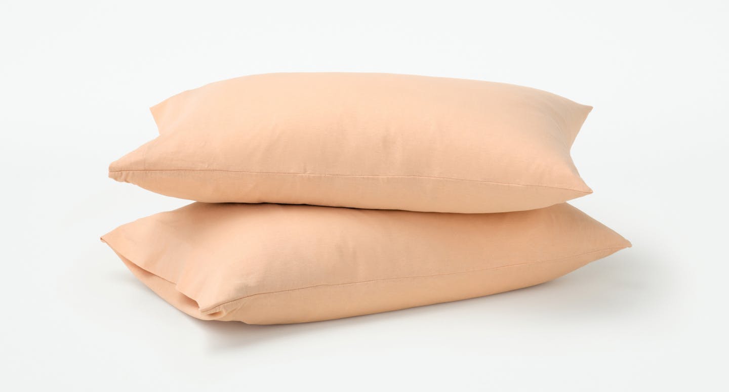 Organic Jersey Pillowcase Set on two pillows in Melon color.