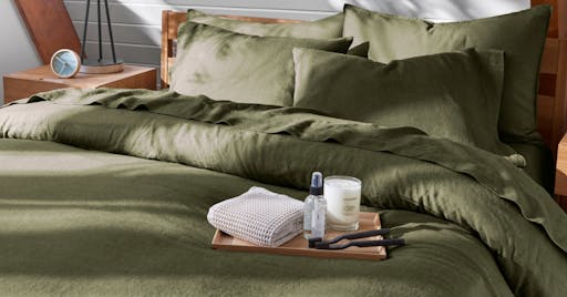 Linen Sheets and Duvet on made bed in Moss color. 