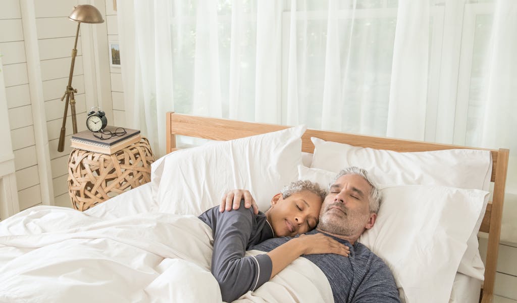 Older couple sleeping in bed.
