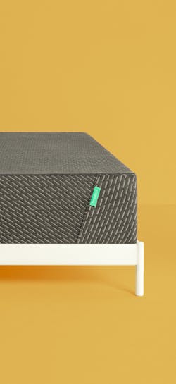The Classic Mint Mattress on a white frame on a marigold background.
