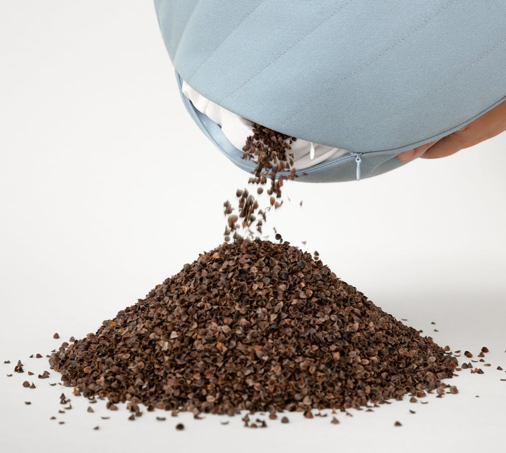 Meditation Cushion is open and pouring hulls to demonstrate that it's refillable.