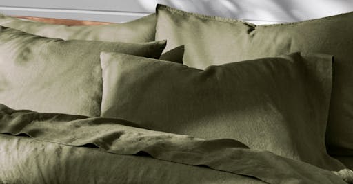 Linen Sheets and Duvet on made bed in Moss color. 