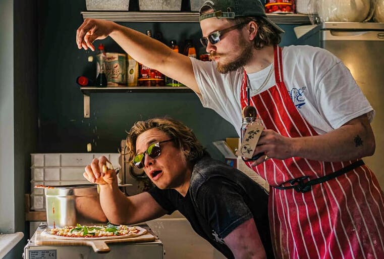 2 men making pizza