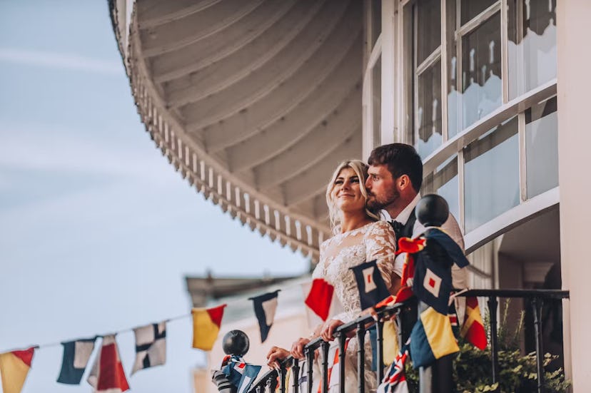 wedding couple on balcony with flags