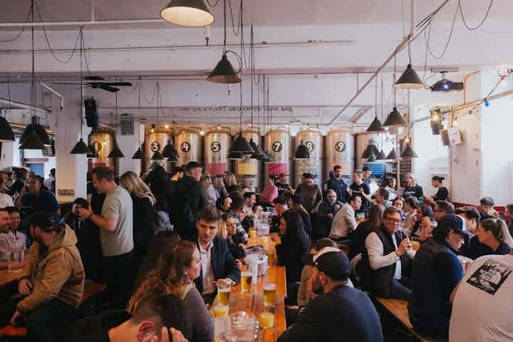 Long tables with people sitting drinking and chatting