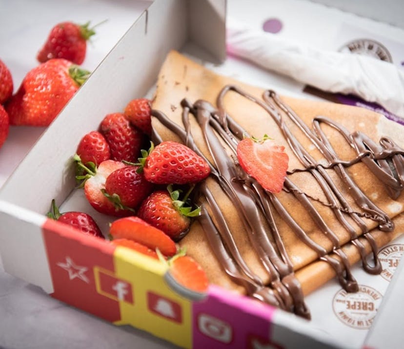 crepes in a box with strawberries and chocolate sauce