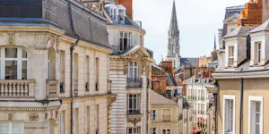 Typical French urban street lined with historic buildings and cafés.