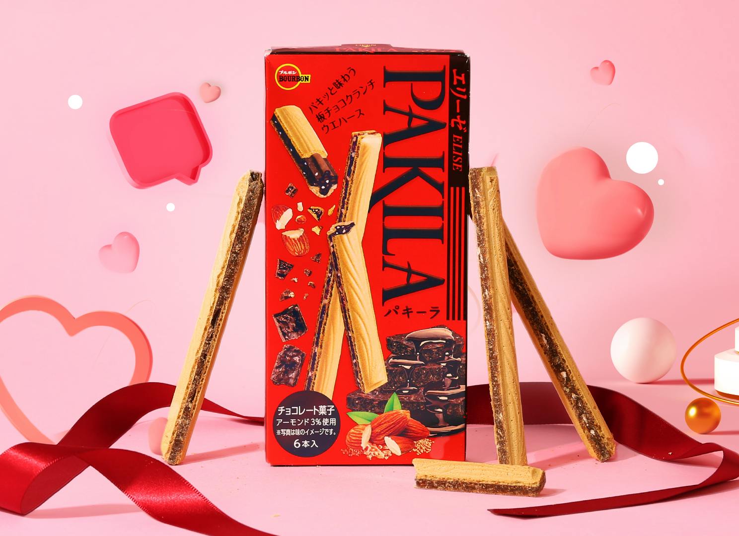 Pakila chocolate wafers stand near pink Valentine's Day hearts and a red ribbon