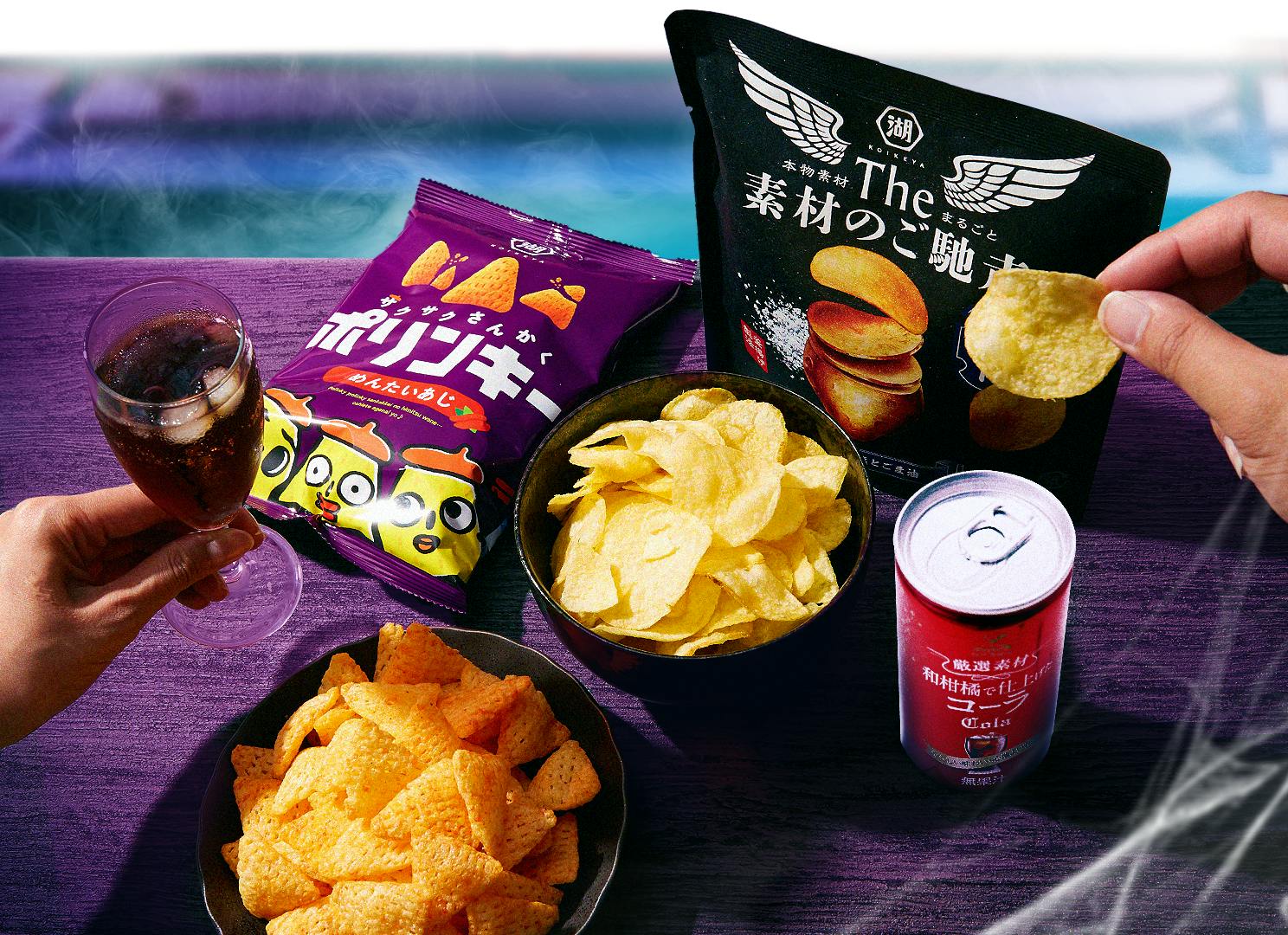 Chips & cola items from the Halloween SnackHaul box sit on a purple table with Halloween details in the background. Chips & cola items from the Halloween SnackHaul box sit on a purple table with Halloween details in the background.
