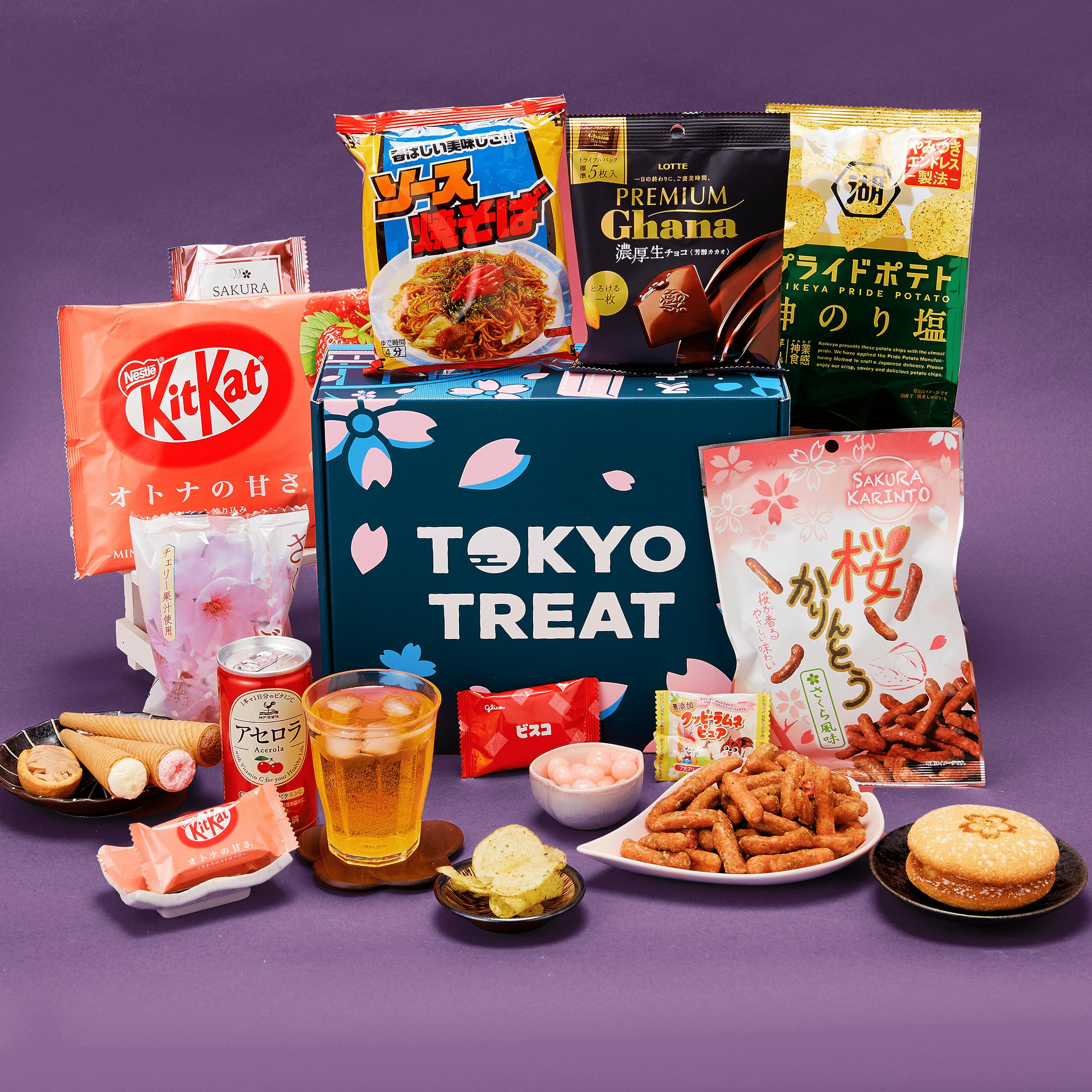 The special-edition TokyoTreat Night Time Sakura box sits  against a dark purple backdrop surrounded by Sakura box items.