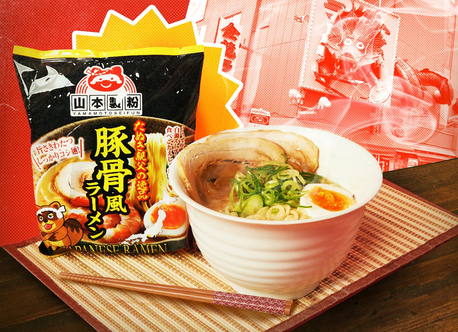 A bowl of tonkotsu ramen is topped with an egg, green onions, and pork and sits on a bamboo mat