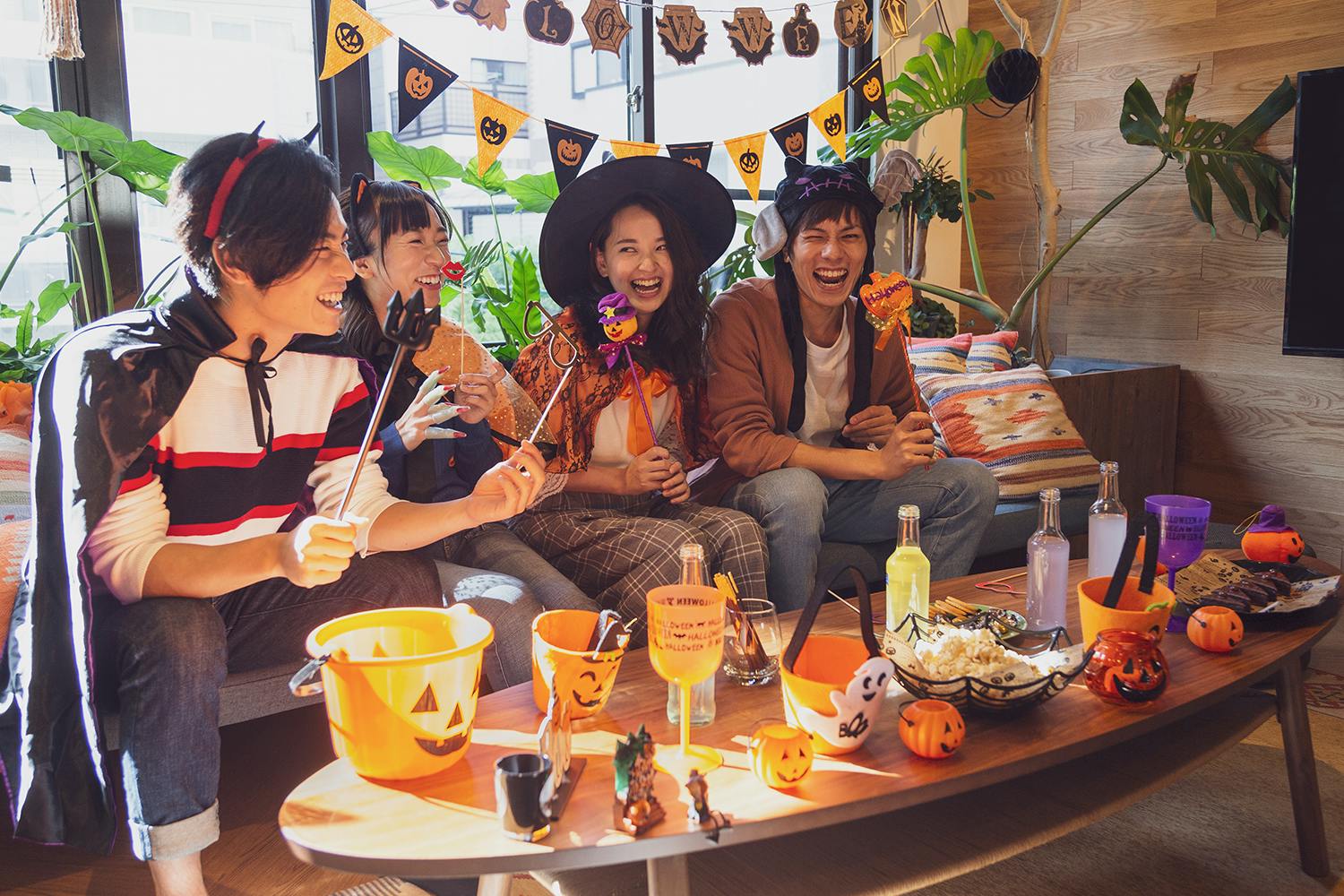 A scene of a Halloween party in Japan, with attendees dressed in Halloween costumes, and Halloween snacks & decor adding a spooky vibe to the party.