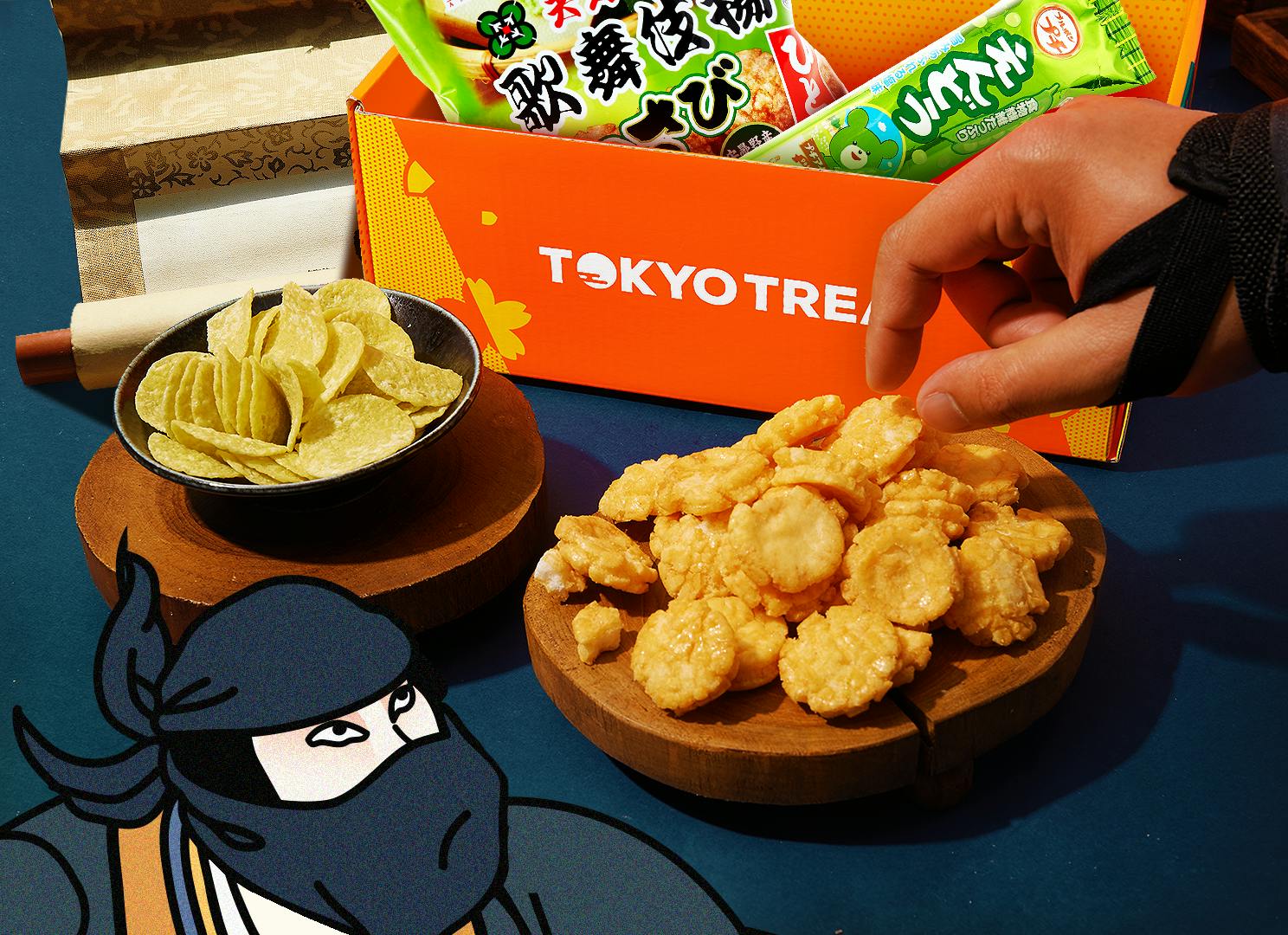 Endou Pea Chips and Kabuki Wasabi Rice Crackers sit against a dark blue backdrop, surrounded by ninja motifs.