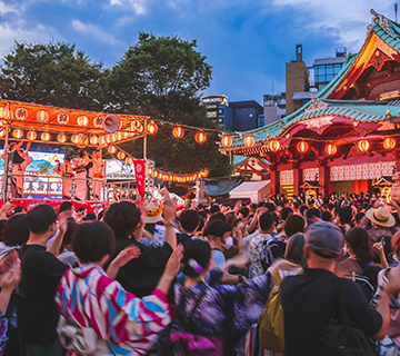A crowd of dancing festival-goers at a Japanese summer festival.