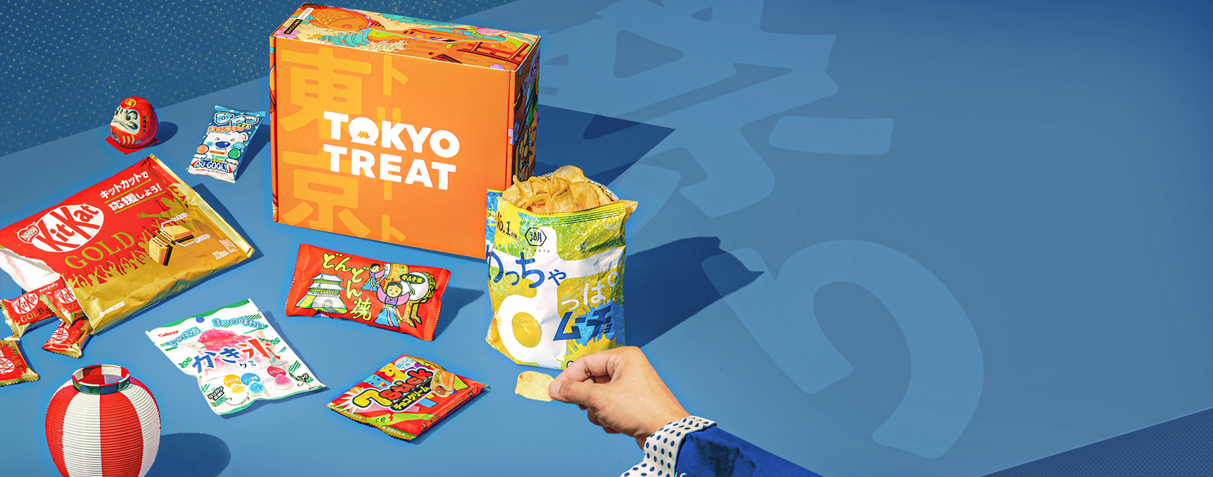 TokyoTreat box sits on a blue background, surrounded by Summer Matsuri Flavorfest box items.