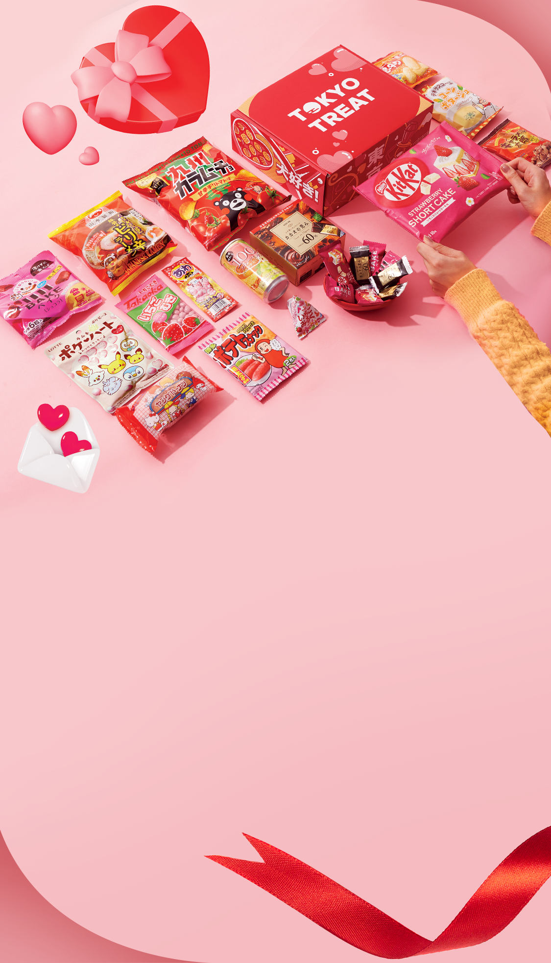 TokyoTreat box sits againt a pink background, surrounded by Valentine items and motifs.