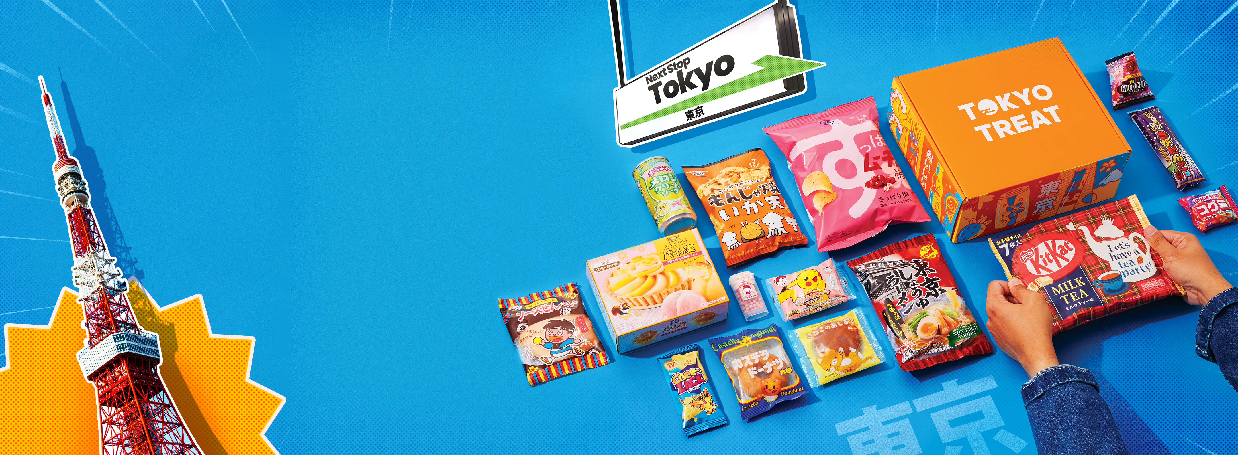 TokyoTreat box lays against a blue backdrop, surrounded by all box items.