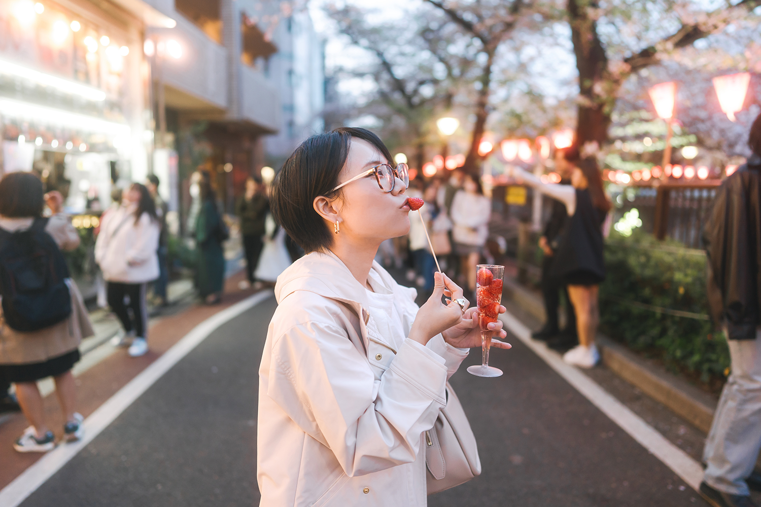 A woman enjoys a famous sakura champagne drink at a cherry blossom festival in Tokyo.