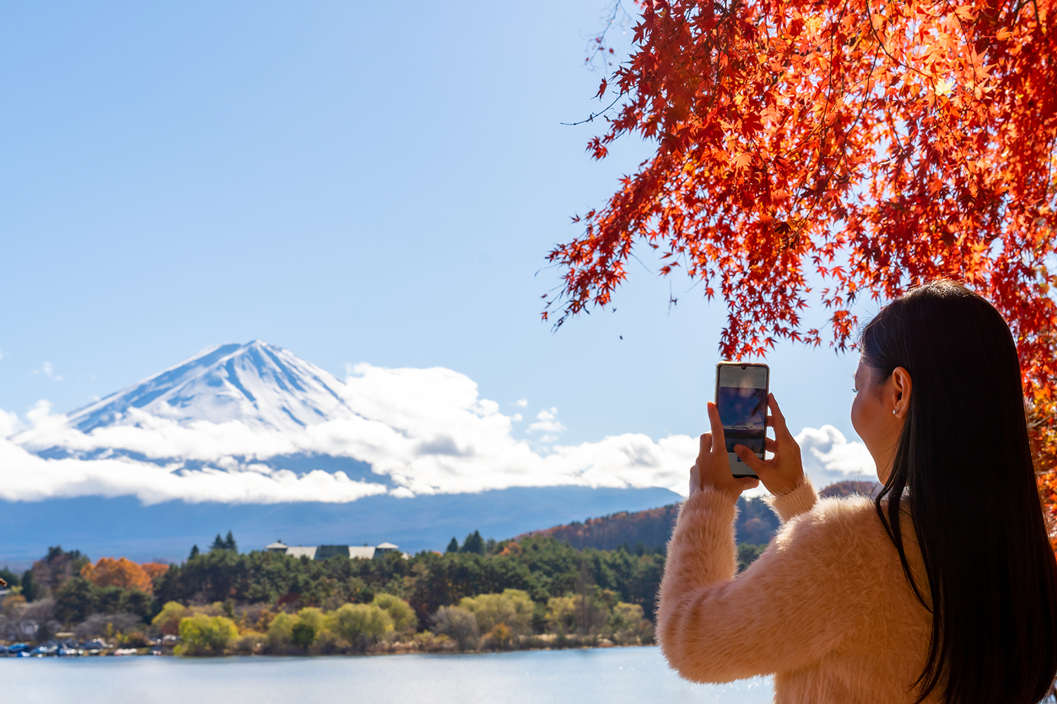 A woman takes a photo of Mt. Fuji.