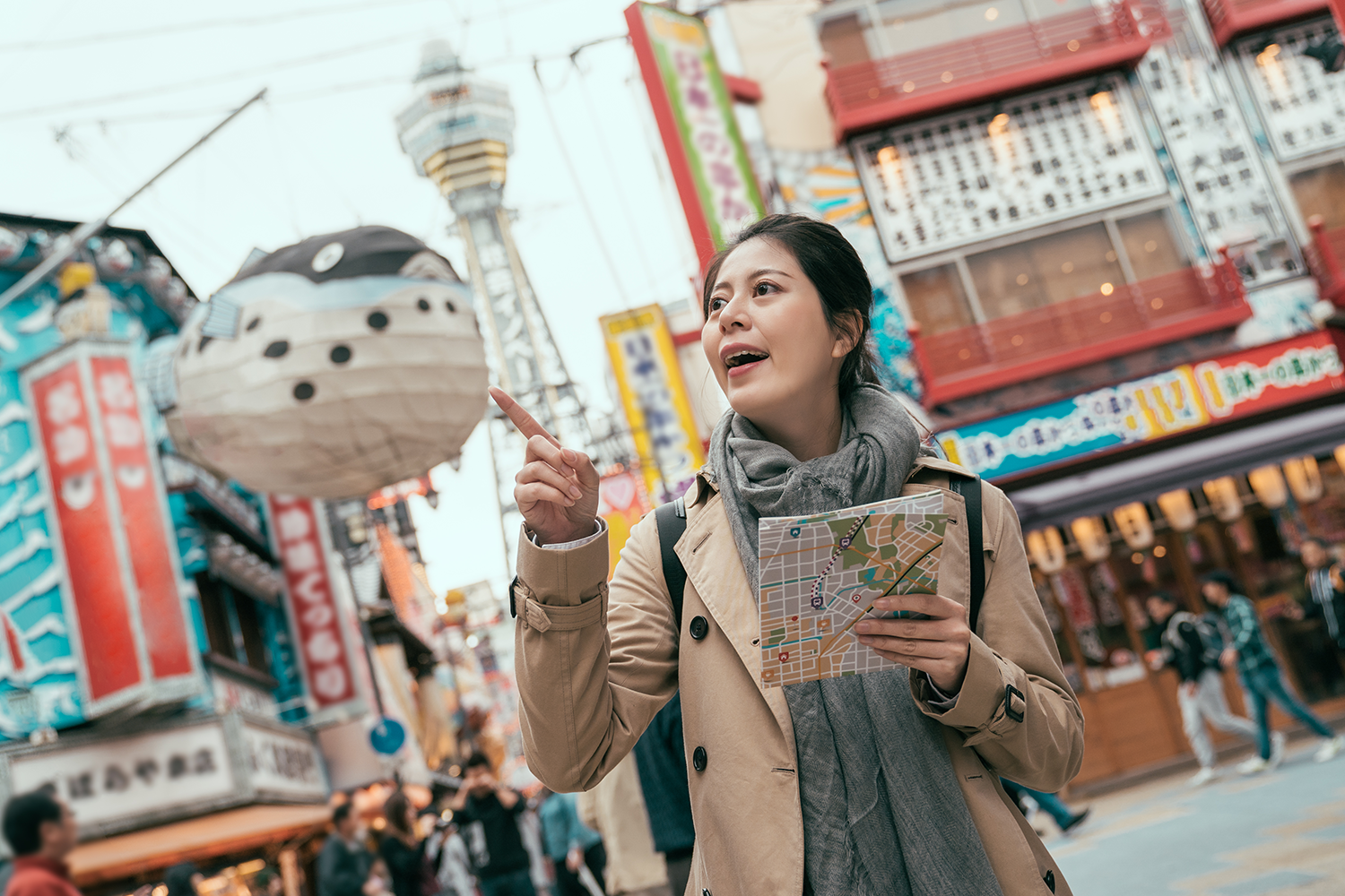 A female tourist explores Osaka's downtown district.