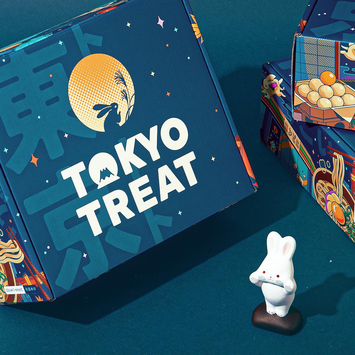 The special-edition Moon Festival TokyoTreat box sits on a blue background, next to a small white rabbit statue.