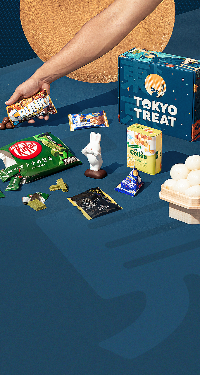 The special limtied-edition Moon Festival TokyoTreat box sits on a dark blue background, surrounded by themed snacks and Tsukimi motifs.