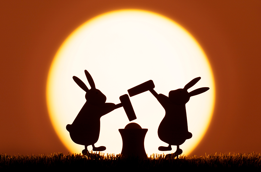 The shadows of two bunnies are pounding mochi in front of the moon.