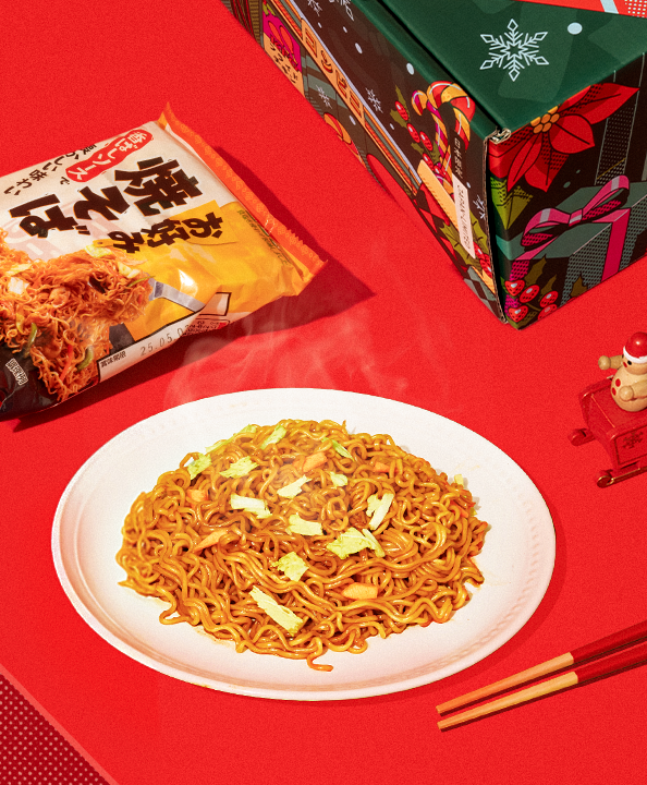 A plate of tasty yakisoba against a red background.