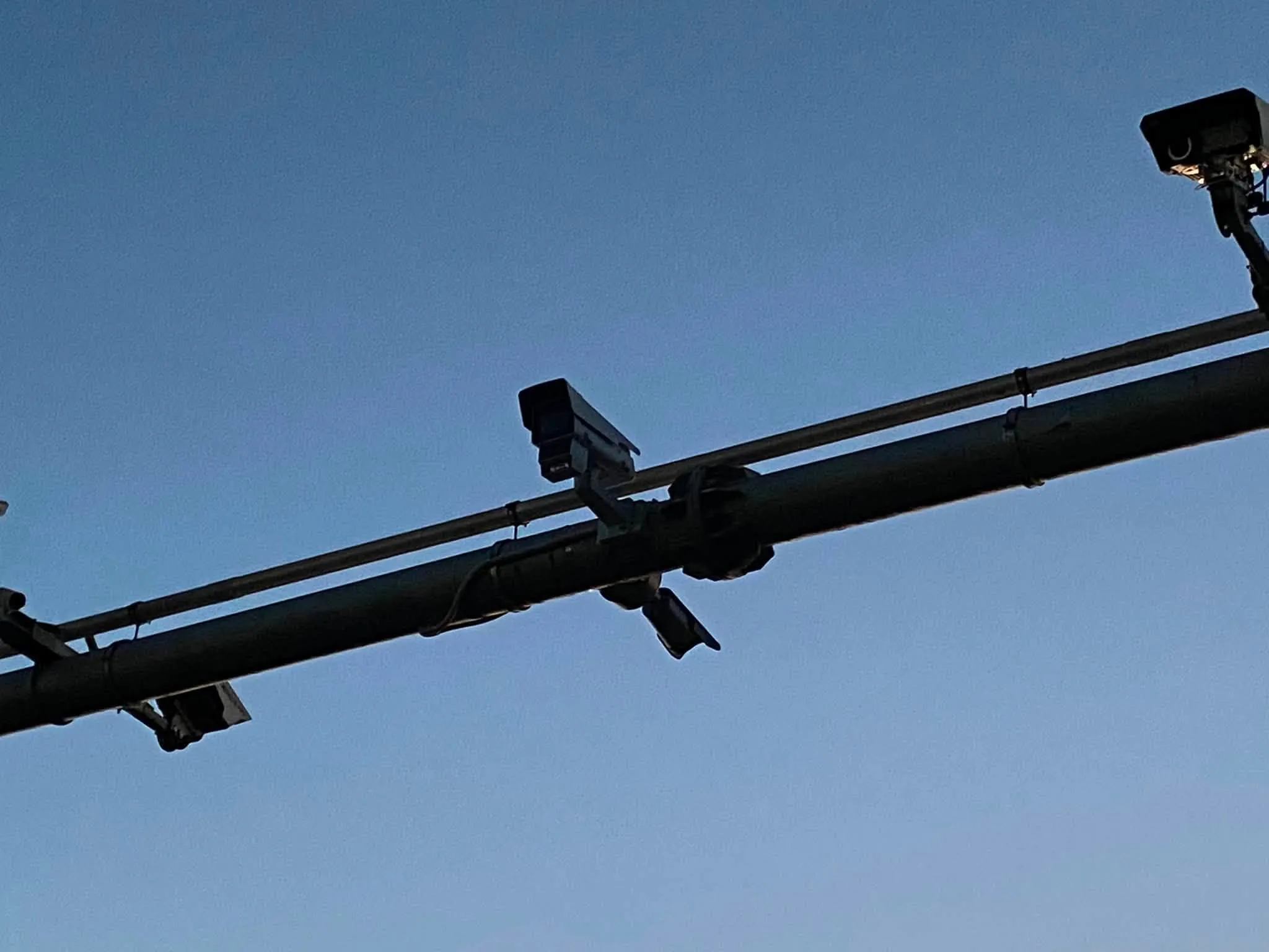 A camera on a gantry over the carriageway — the structure has been there for years, the camera has not