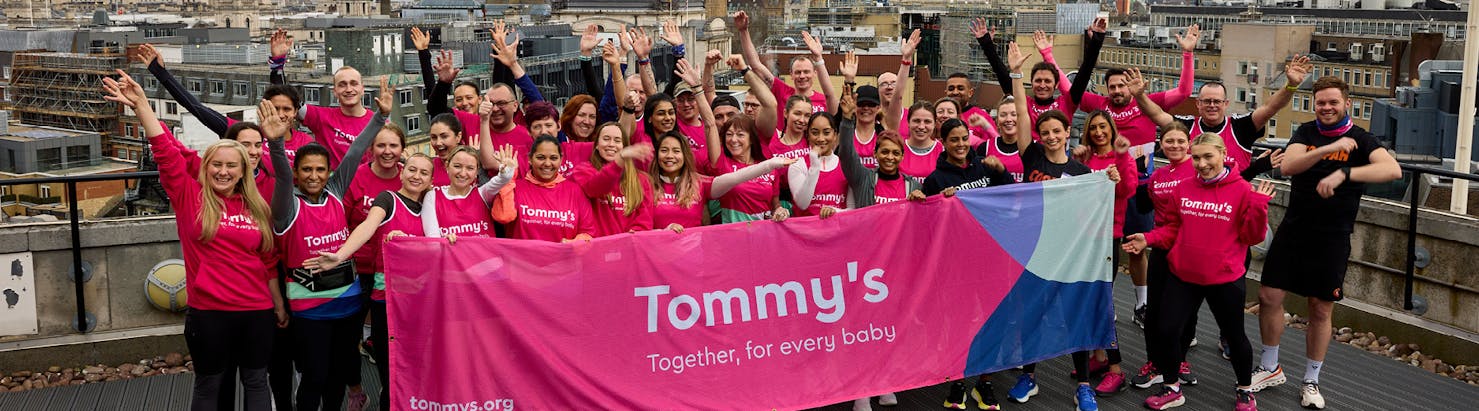 Team Tommy's holding a branded banner
