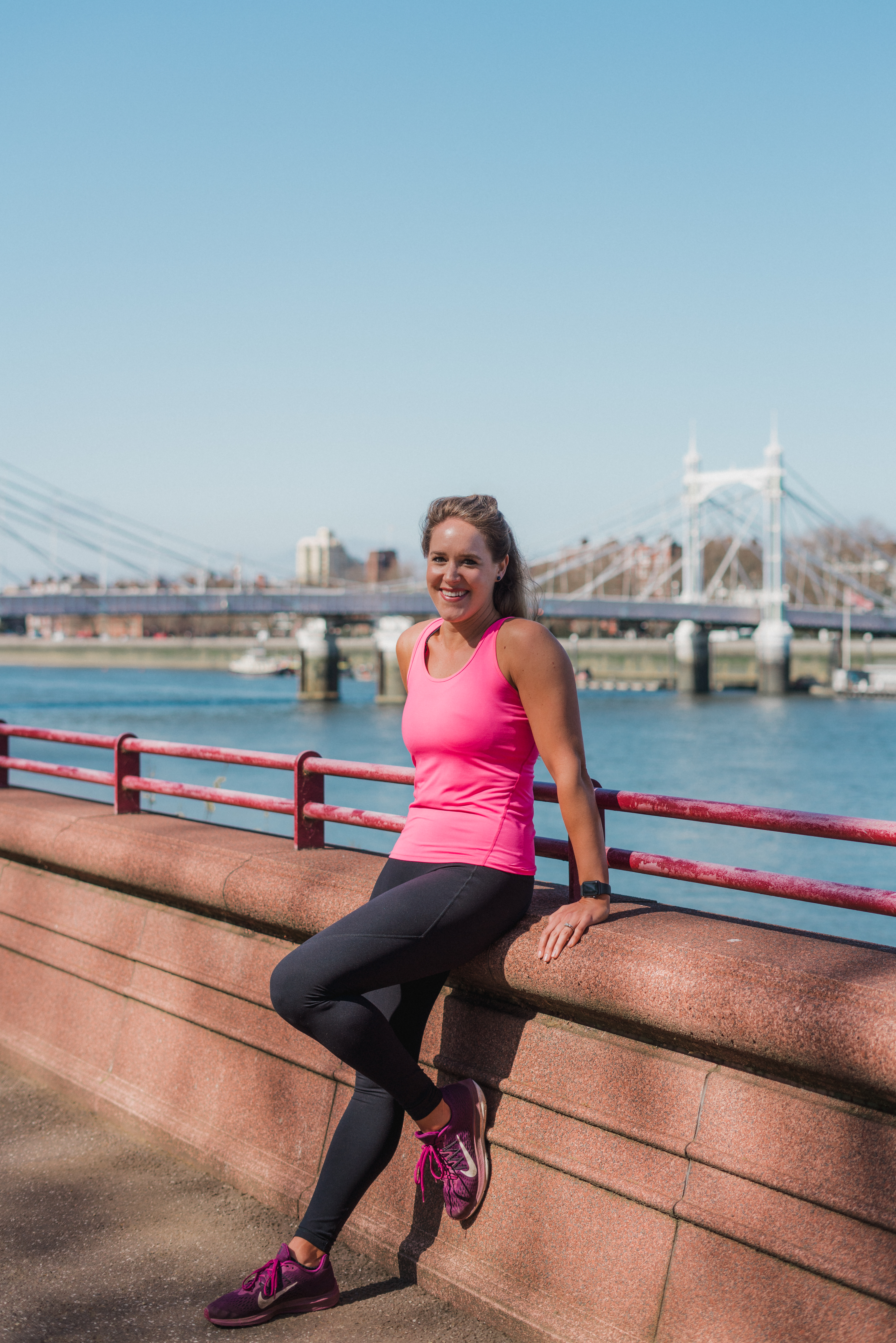 Lady posing in front of a bridge