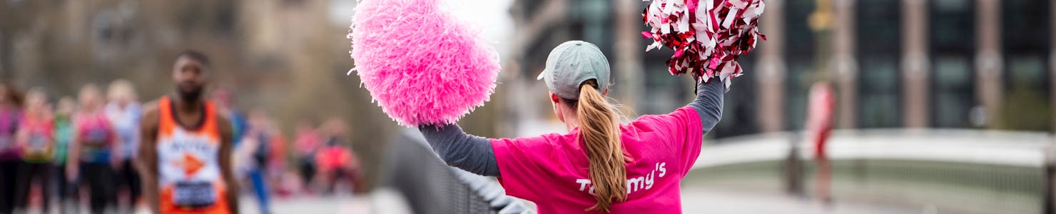 Supporter holding pom poms facing away from the camera