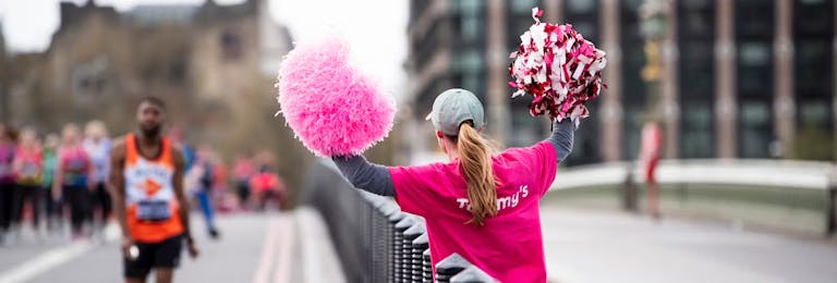 Supporter holding pom poms facing away from the camera