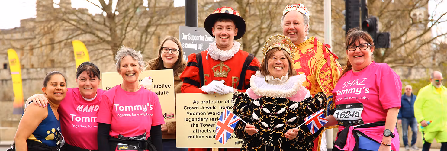 A group of people posing with 3 people in fancy dress