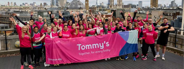 Team Tommy's holding a branded banner