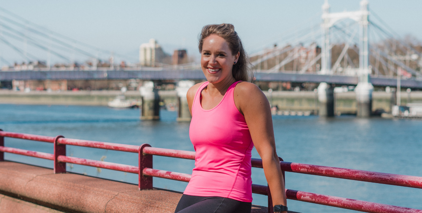 Lady posing in front of a bridge.