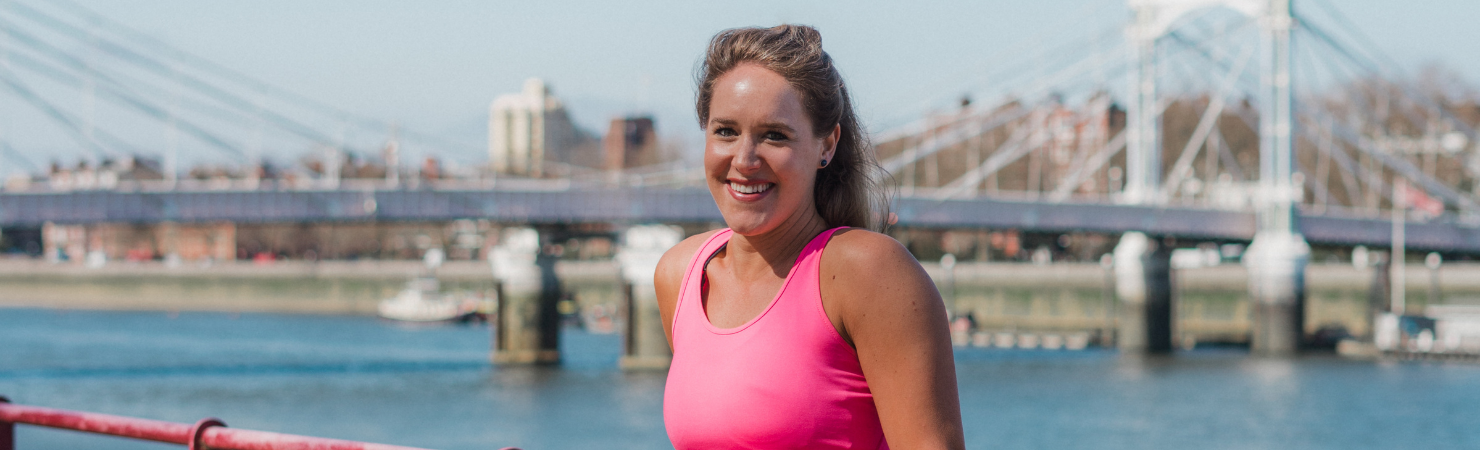 Lady posing in front of a bridge.