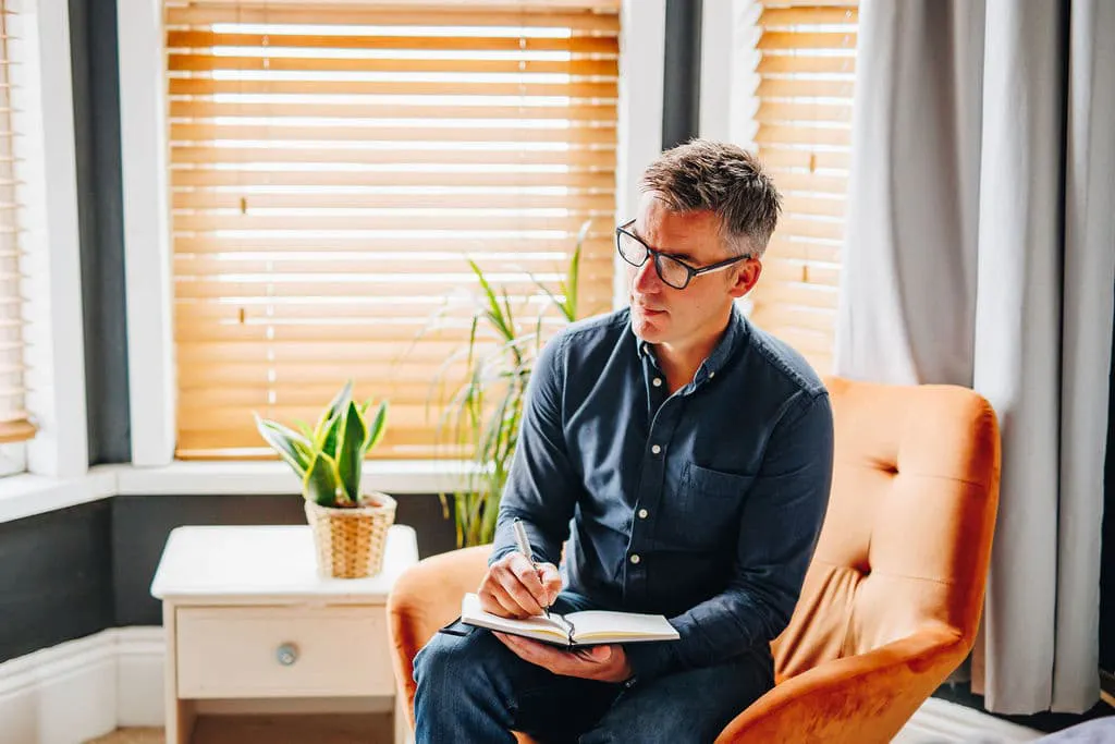 Tony sat in a chair attentively taking notes