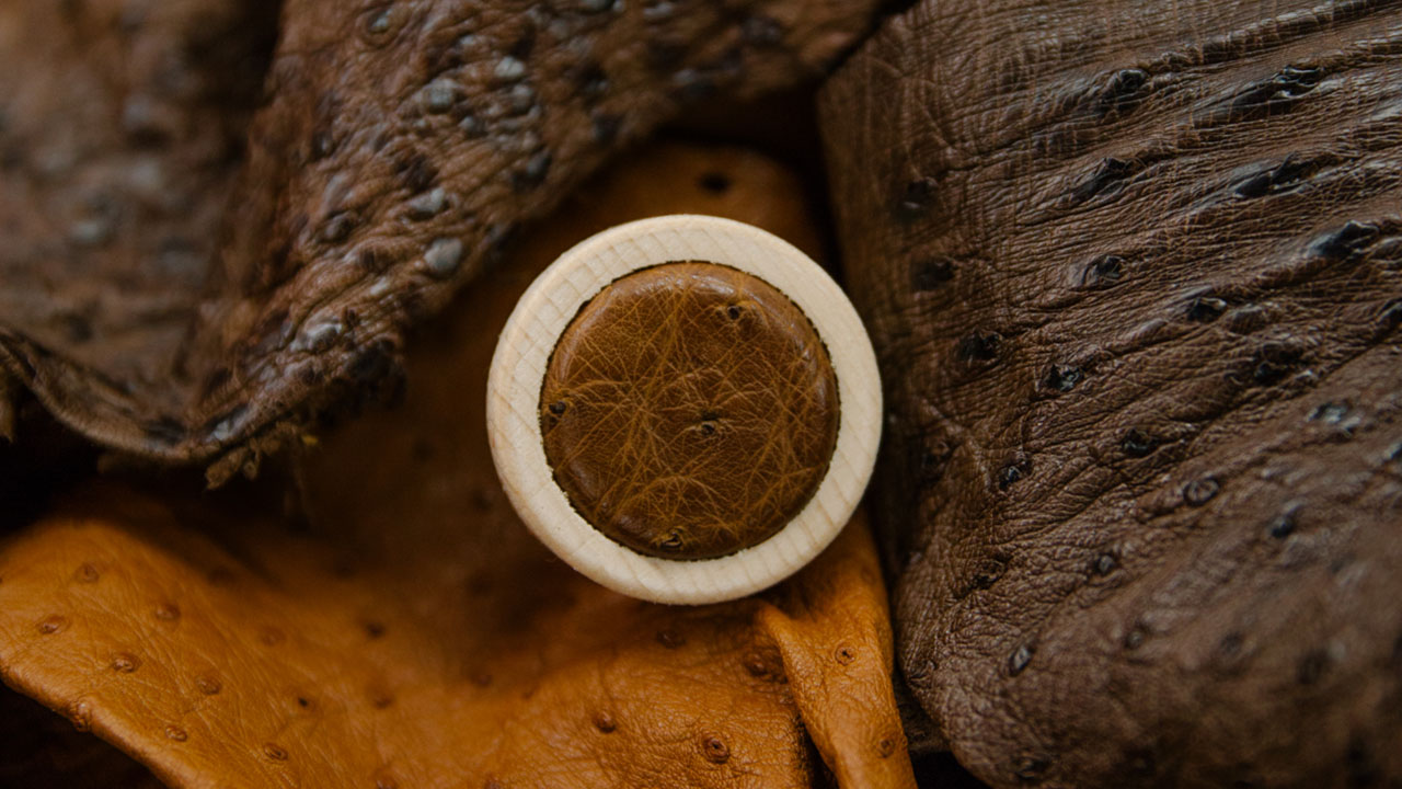 Leather topped bottle cap on leather.