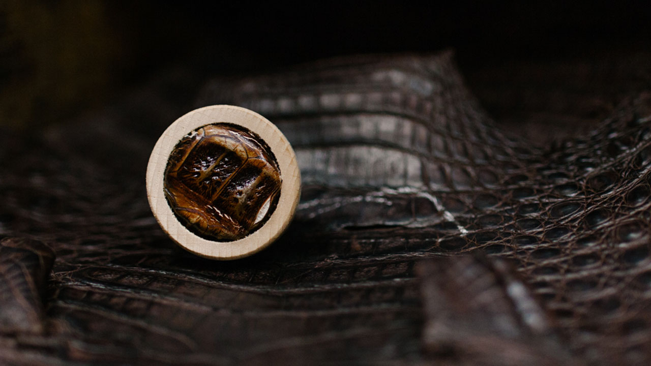 Leather bottle cap on top of lizard skin leather.
