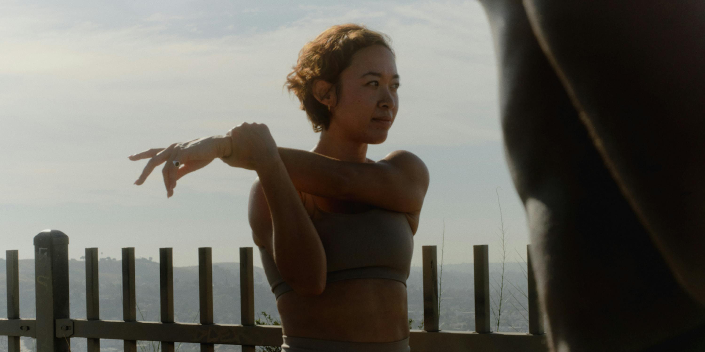 woman standing and stretching her arm